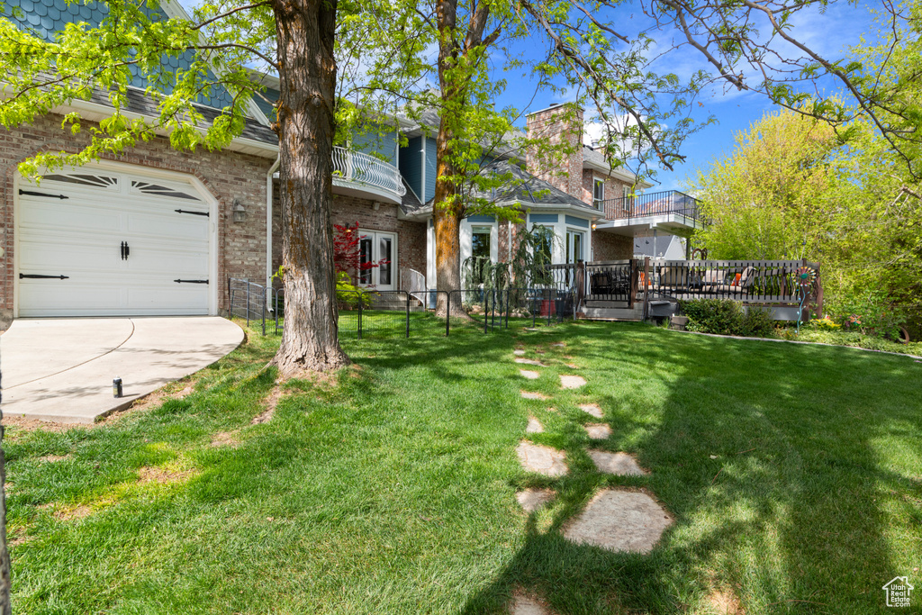 Exterior space featuring fence, a balcony, and driveway