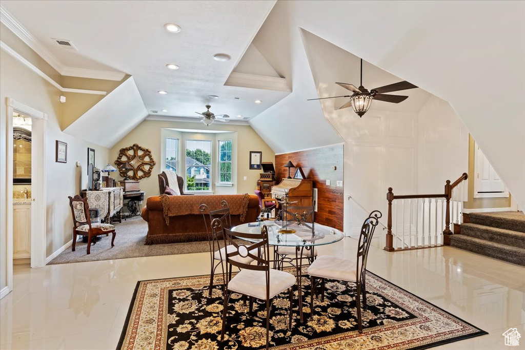 Dining room with crown molding, a ceiling fan, lofted ceiling, and visible vents