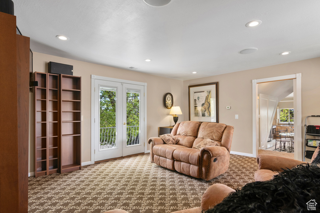 Carpeted living area featuring baseboards, recessed lighting, and a wealth of natural light