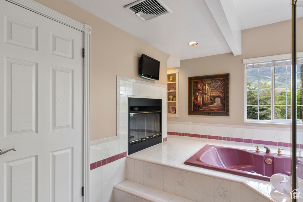Interior space with visible vents, recessed lighting, a tiled fireplace, and tile counters