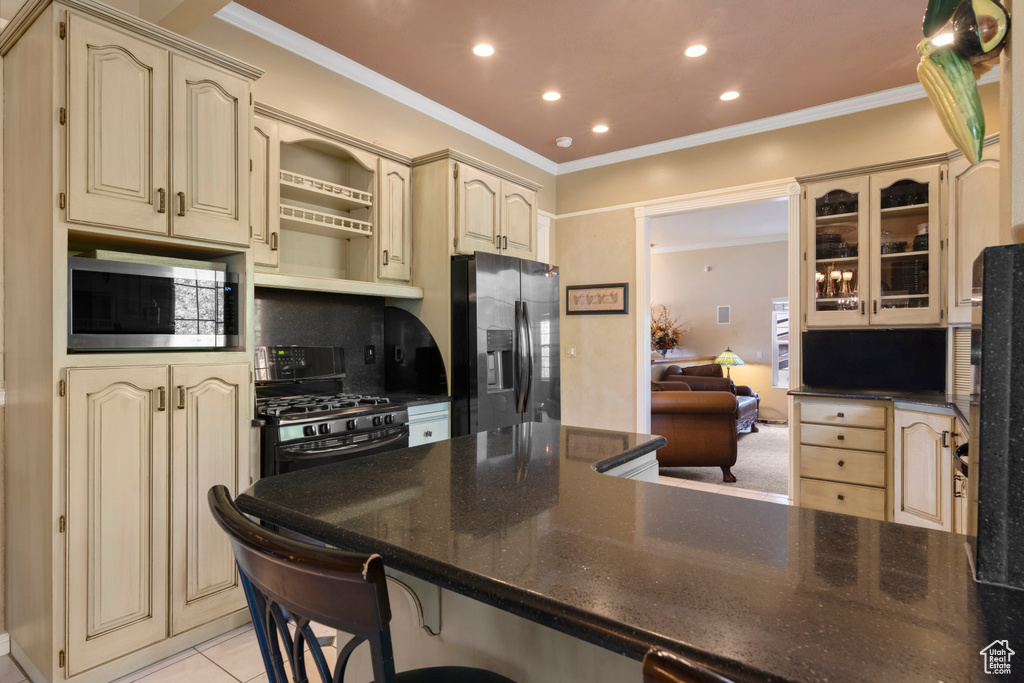 Kitchen featuring stainless steel appliances, recessed lighting, and cream cabinetry
