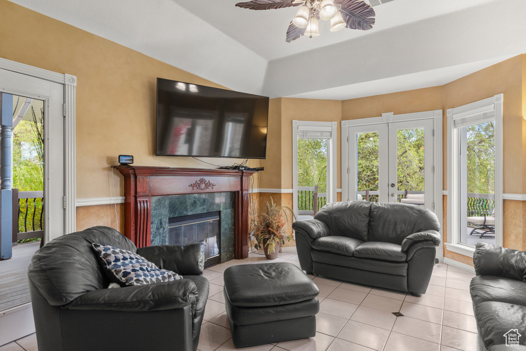 Living area featuring a high end fireplace, tile patterned flooring, french doors, and ceiling fan