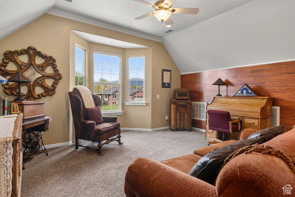 Interior space with visible vents, a ceiling fan, lofted ceiling, and wood walls
