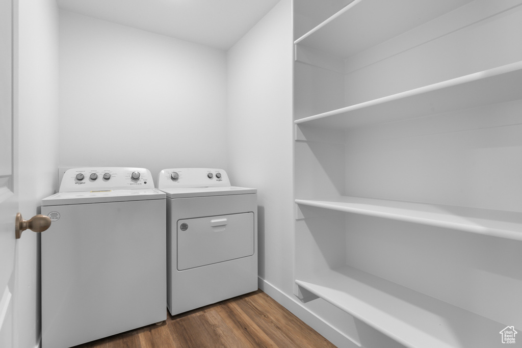 Laundry area featuring laundry area, washing machine and dryer, and dark wood-type flooring