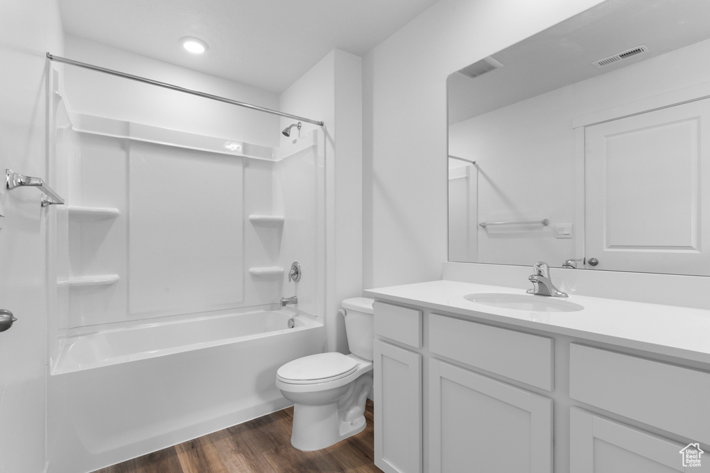 Bathroom with visible vents, bathtub / shower combination, wood finished floors, vanity, and toilet