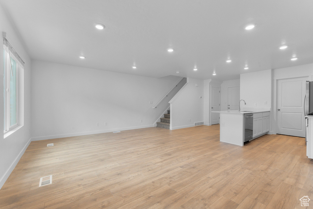 Unfurnished living room featuring visible vents, recessed lighting, stairs, and light wood finished floors