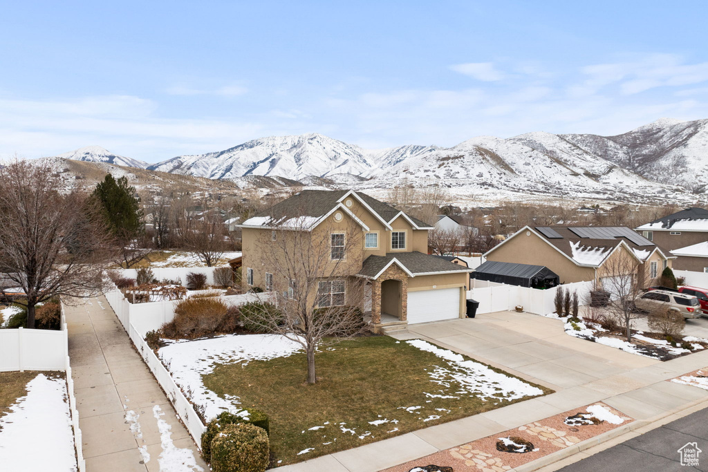 View of front of house with roof with shingles, a mountain view, fence, and concrete driveway