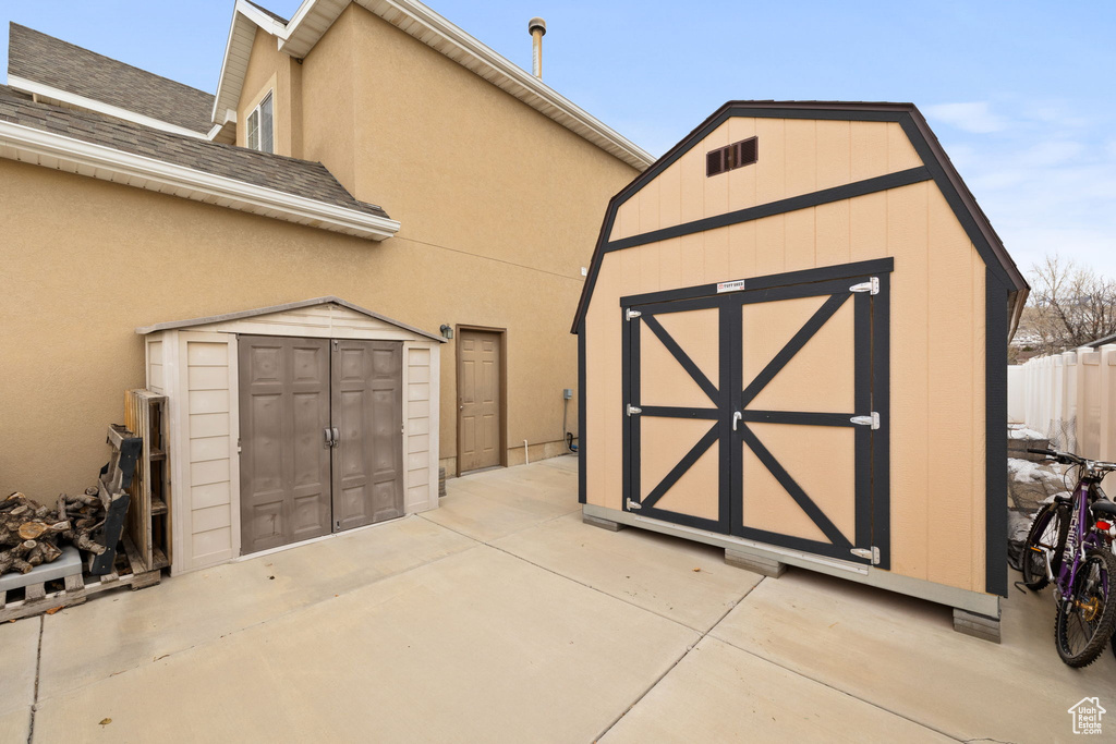 View of shed featuring fence