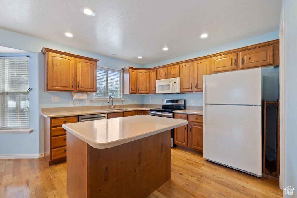 Kitchen featuring a sink, light countertops, brown cabinetry, and stainless steel appliances