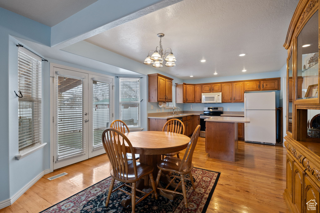 Dining area with recessed lighting, visible vents, an inviting chandelier, and light wood-style flooring