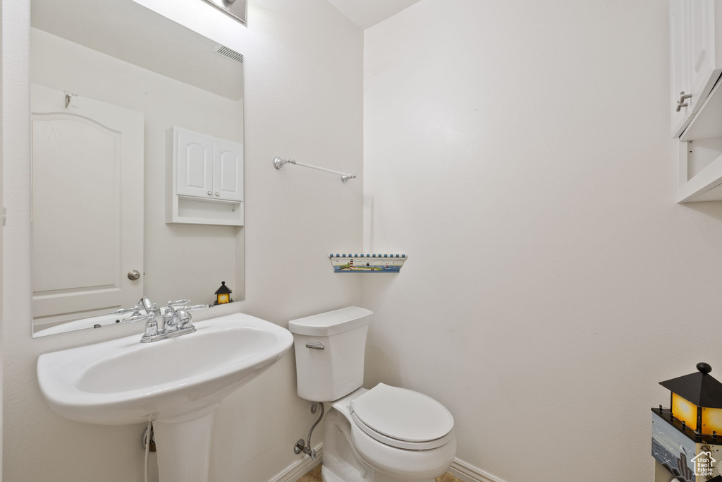 Half bathroom with baseboards and toilet