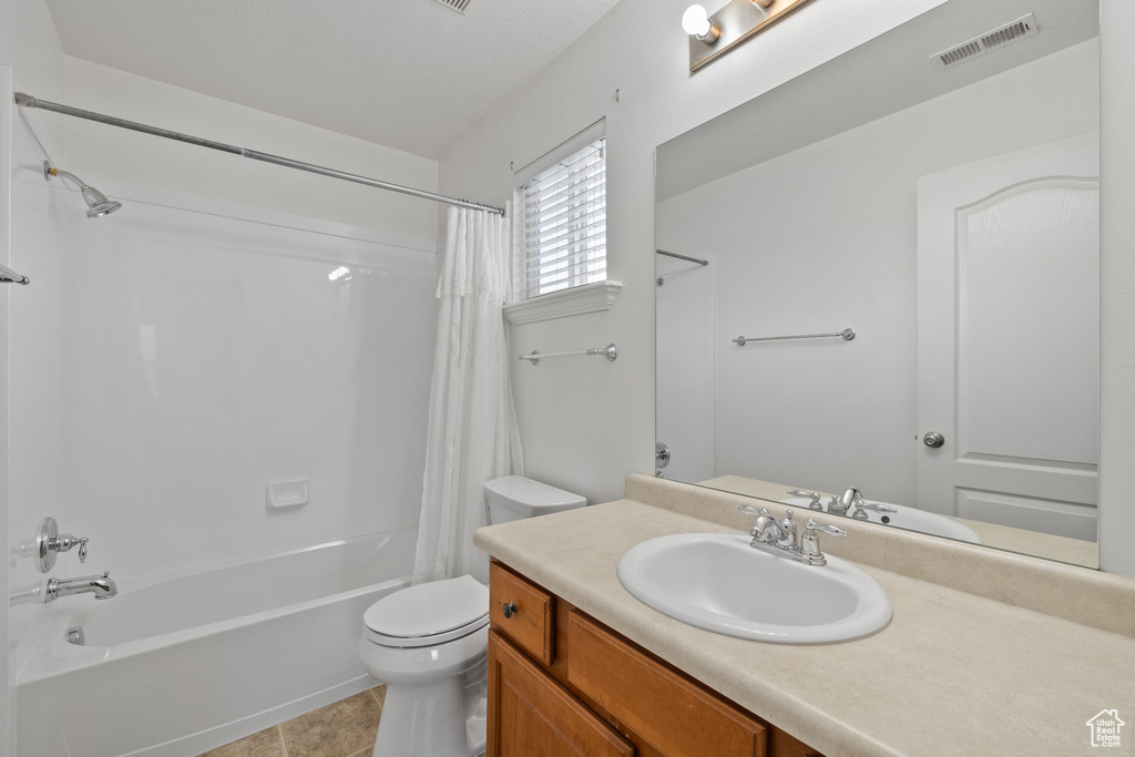 Full bathroom featuring visible vents, tile patterned flooring, shower / tub combo, vanity, and toilet