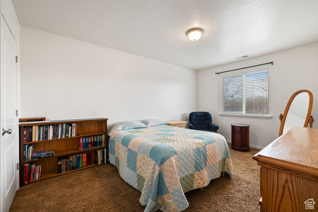 Carpeted bedroom featuring baseboards and visible vents