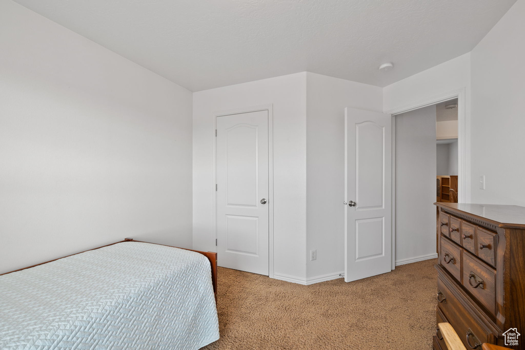 Bedroom with baseboards and light carpet
