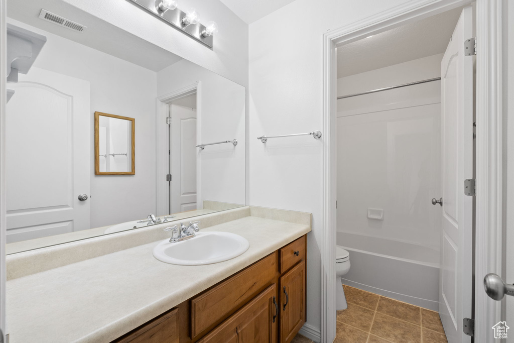 Full bathroom with vanity, shower / bathtub combination, toilet, tile patterned floors, and visible vents