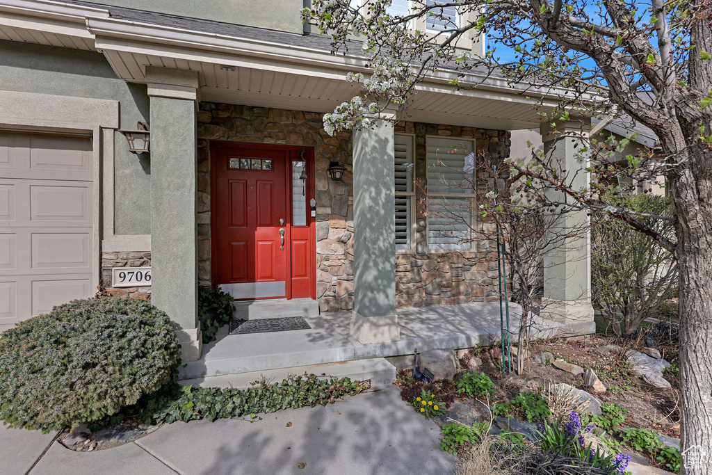 View of exterior entry featuring a porch and stone siding