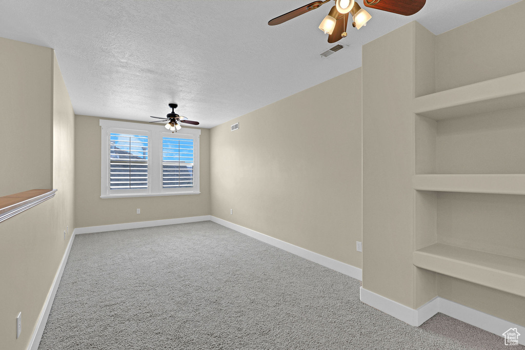 Spare room featuring baseboards, ceiling fan, and carpet flooring