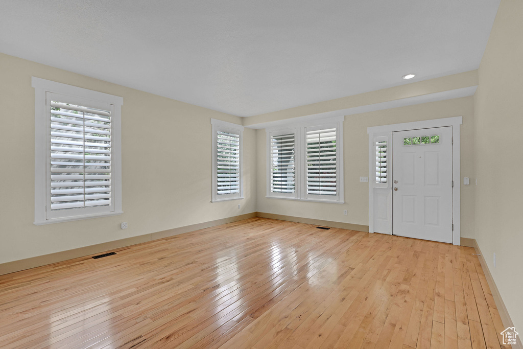 Foyer entrance with visible vents, baseboards, and hardwood / wood-style floors