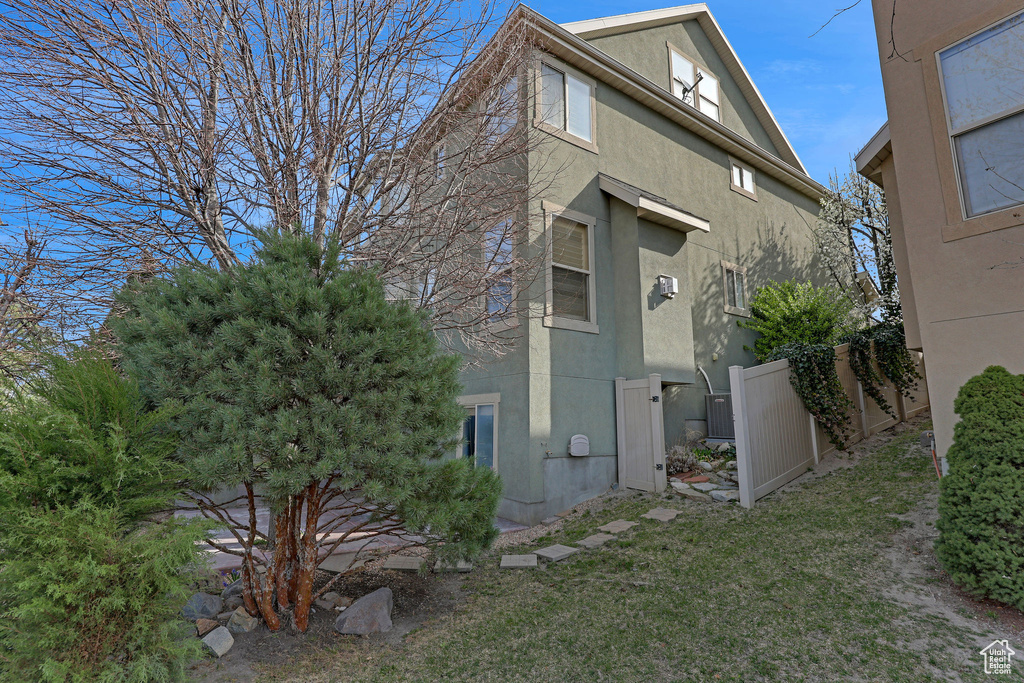 View of side of home featuring stucco siding and fence