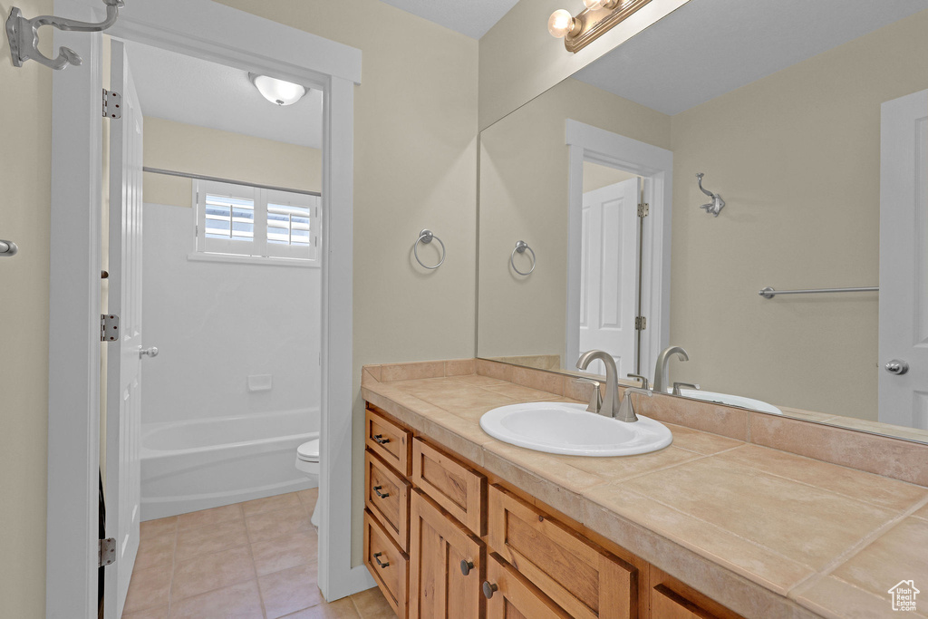Full bathroom featuring vanity, tub / shower combination, tile patterned floors, and toilet