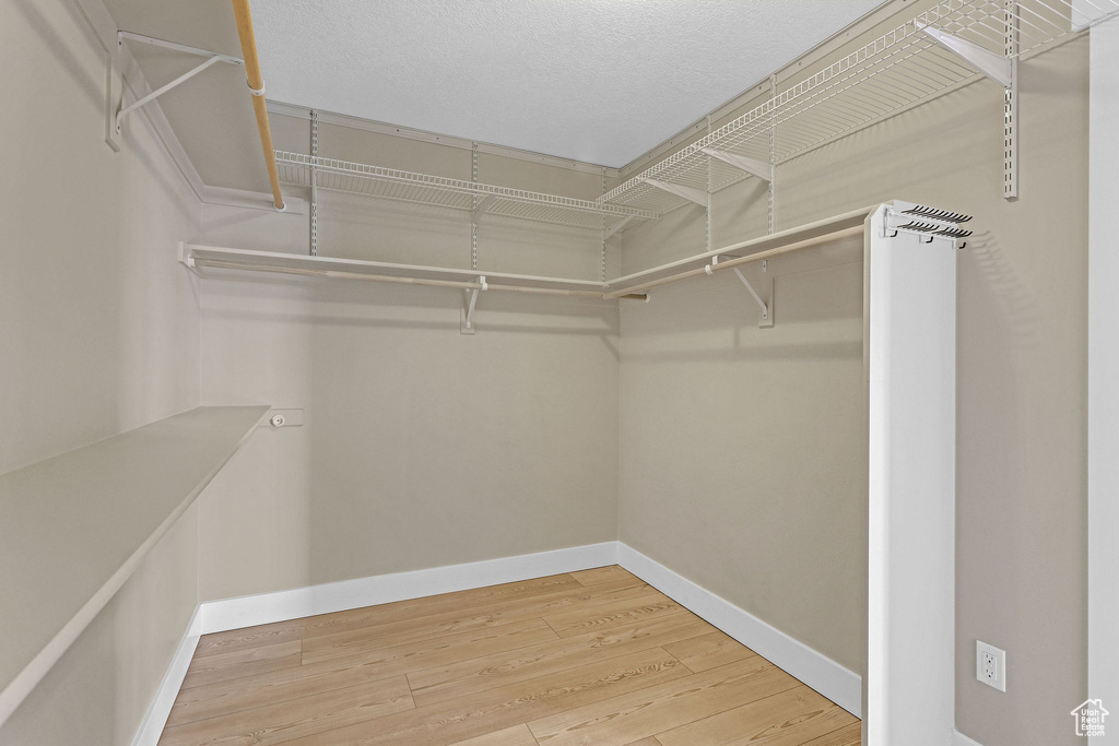 Walk in closet with wood finished floors