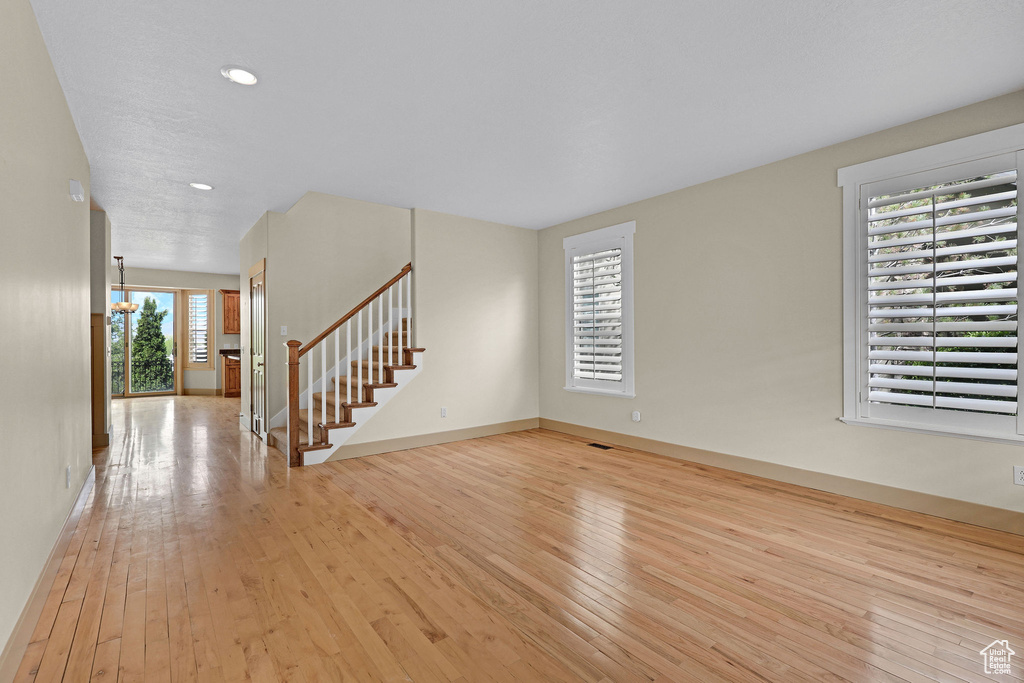 Interior space with stairway, baseboards, recessed lighting, and light wood finished floors