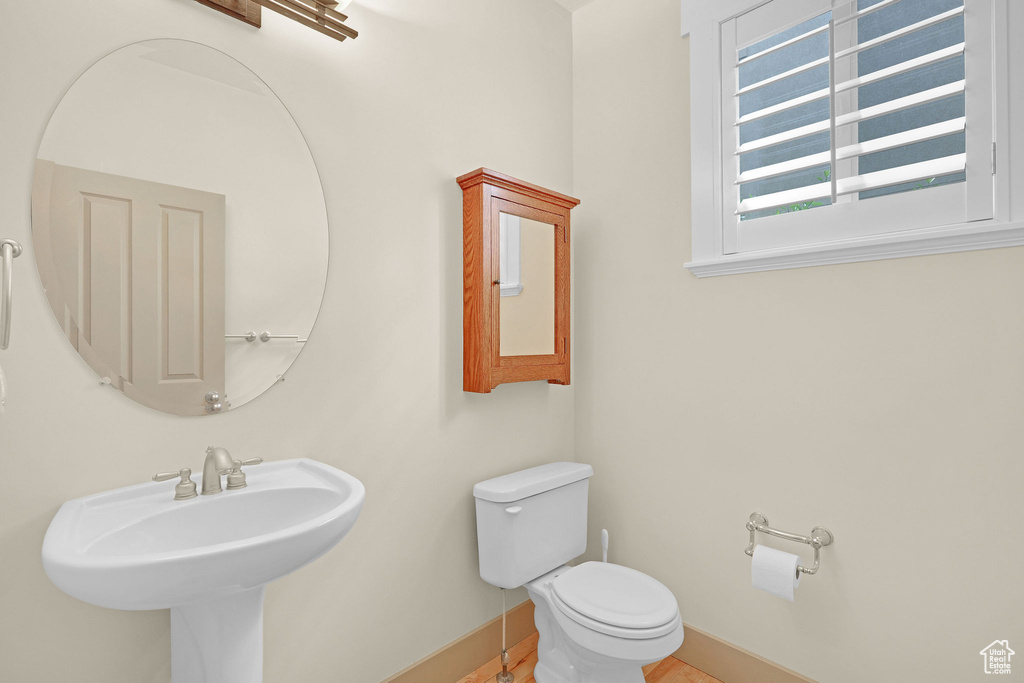 Half bath featuring a sink, baseboards, and toilet