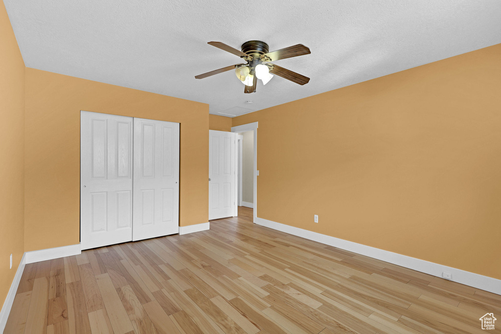 Unfurnished bedroom with baseboards, ceiling fan, light wood finished floors, and a closet