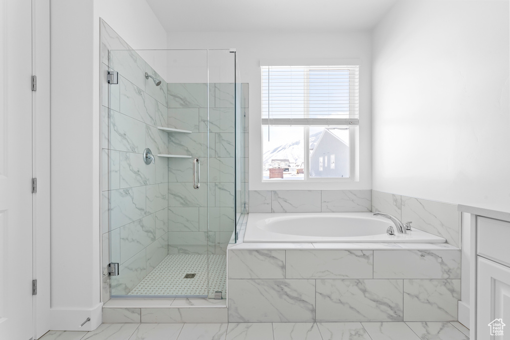 Bathroom with a shower stall, a garden tub, and marble finish floor