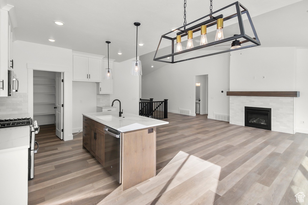 Kitchen with recessed lighting, a sink, appliances with stainless steel finishes, and light wood-type flooring