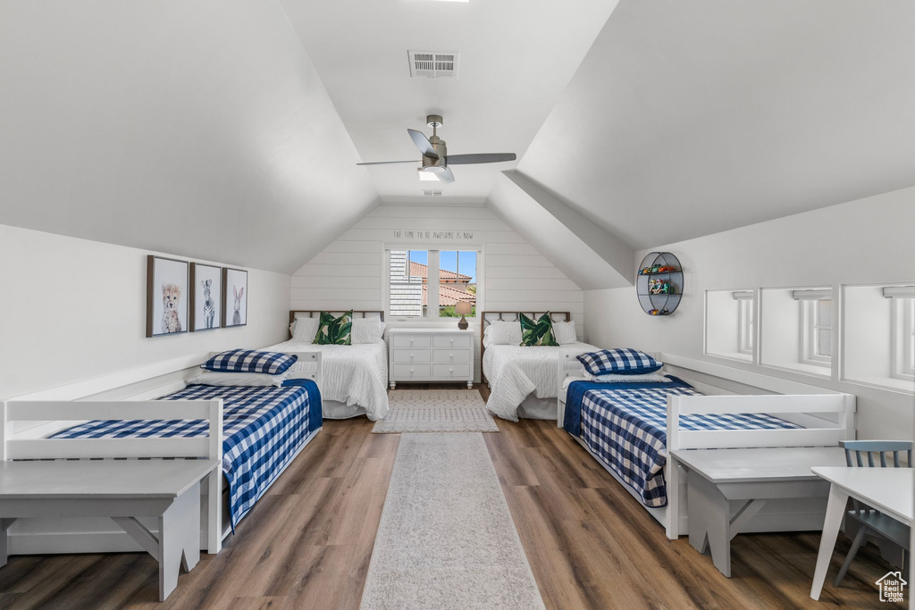 Bedroom with visible vents, a ceiling fan, lofted ceiling, and wood finished floors