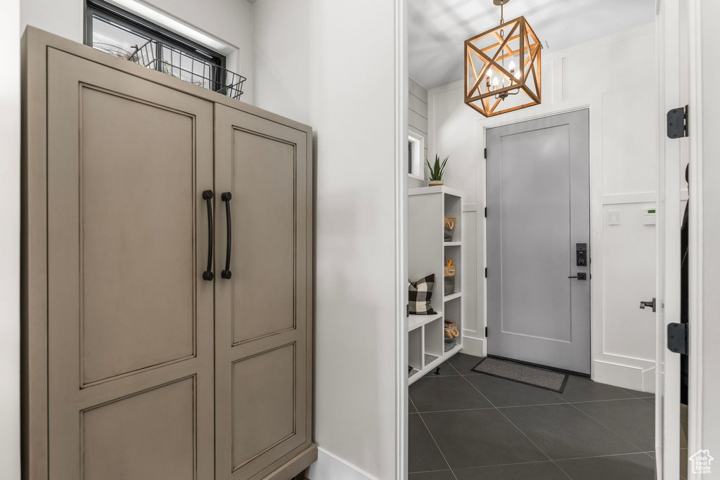 Entrance foyer with an inviting chandelier and dark tile patterned floors