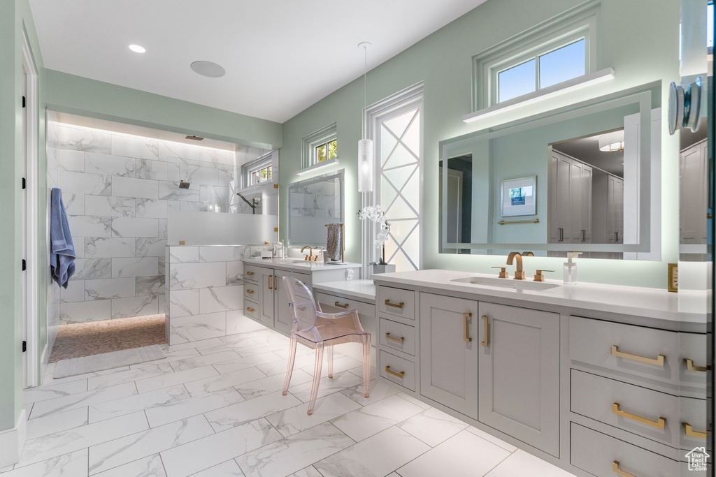 Full bath with a sink, a walk in shower, and marble finish floor