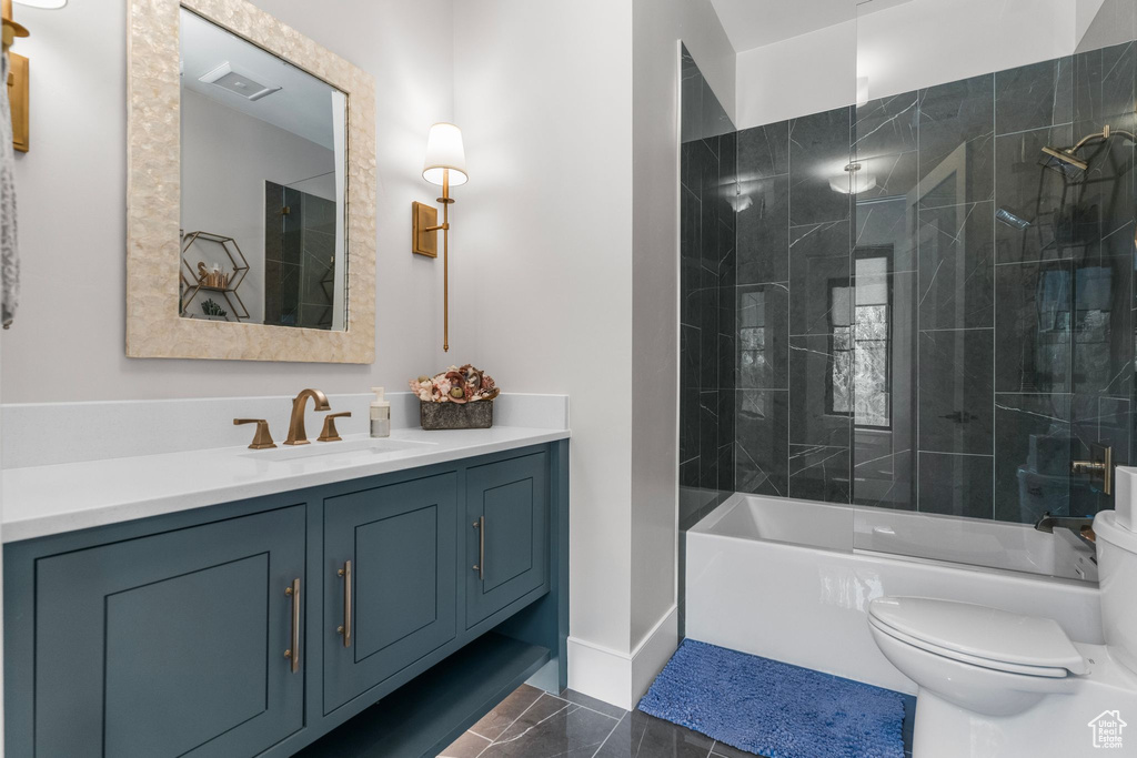 Full bath featuring vanity, marble finish floor, toilet, and tub / shower combination