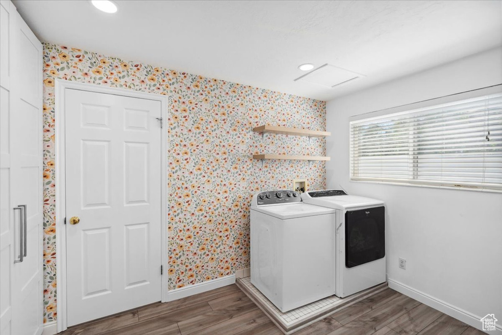 Laundry area featuring laundry area, baseboards, wood finished floors, and washer and dryer
