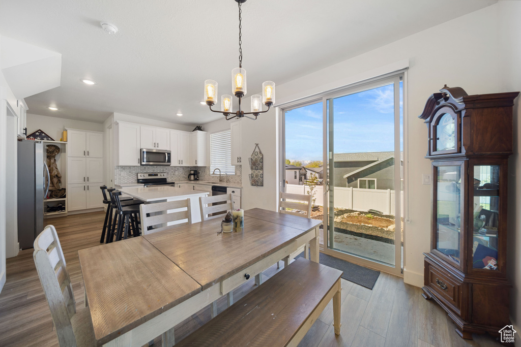 Dining space featuring recessed lighting, wood finished floors, and a notable chandelier