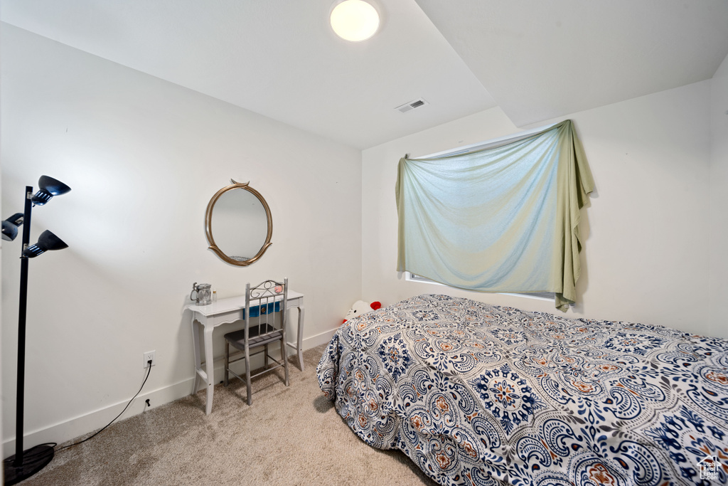 Carpeted bedroom featuring visible vents and baseboards