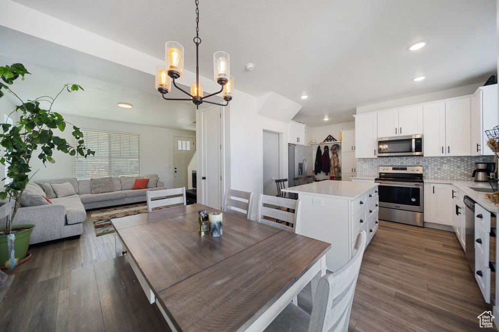 Dining area with an inviting chandelier, recessed lighting, and dark wood-type flooring