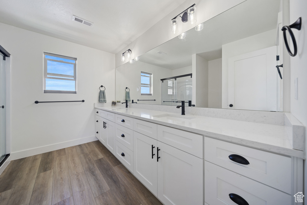 Full bath featuring a sink, a healthy amount of sunlight, a shower stall, and visible vents