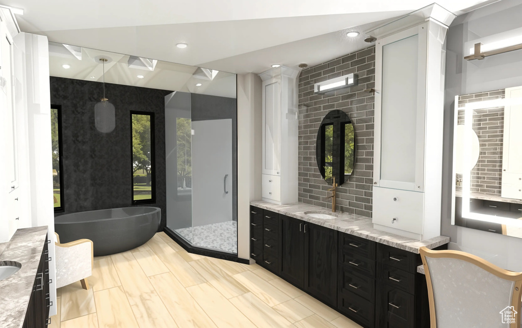 Full bathroom with a freestanding tub, plenty of natural light, a shower stall, and two vanities