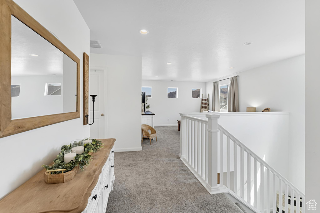 Hallway with visible vents, light carpet, baseboards, recessed lighting, and an upstairs landing