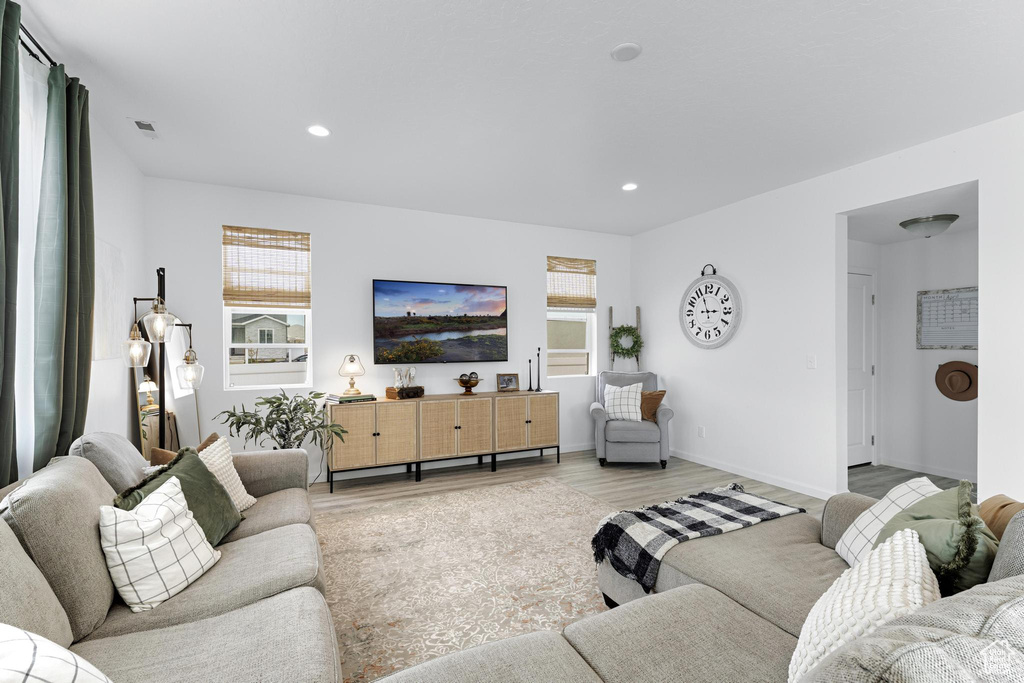 Living room featuring recessed lighting, baseboards, visible vents, and light wood-style flooring