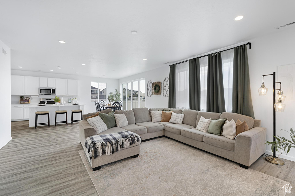 Living room with visible vents, recessed lighting, and light wood-style floors