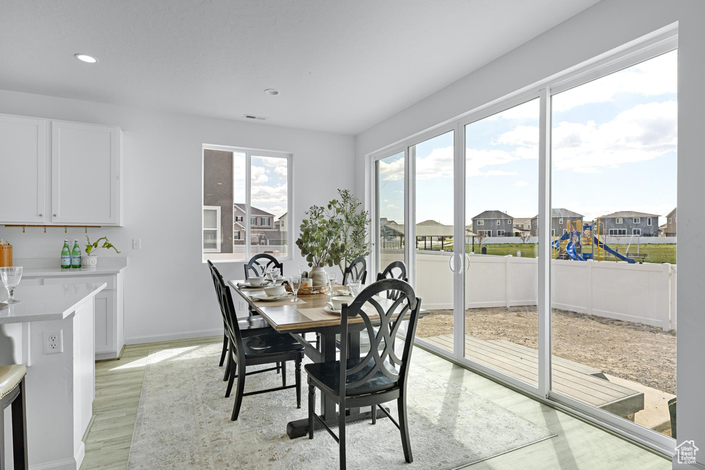 Dining space with visible vents, a residential view, baseboards, recessed lighting, and light wood-style flooring