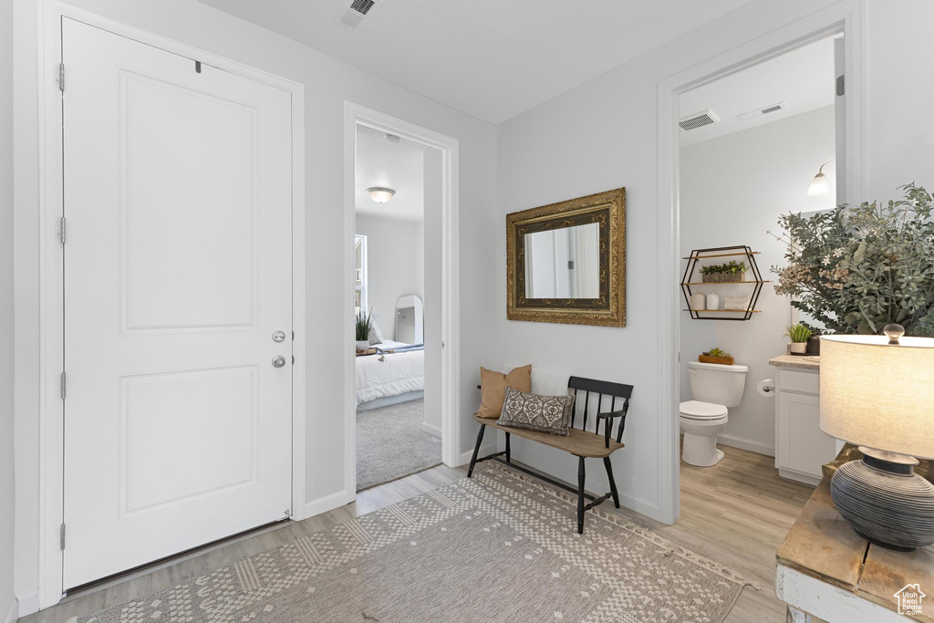 Bathroom with toilet, visible vents, wood finished floors, and vanity