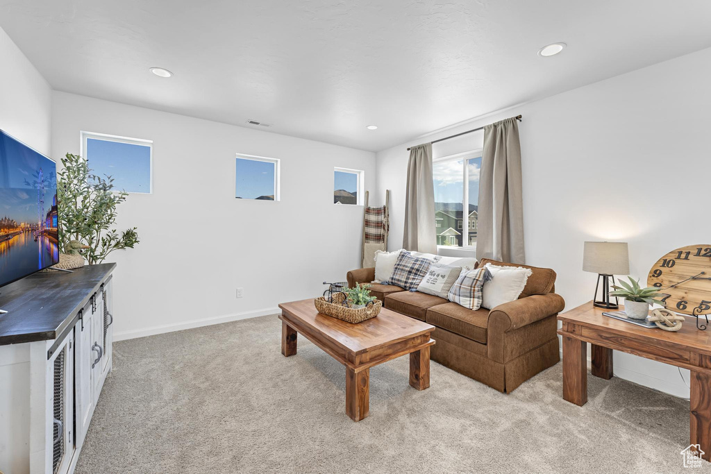 Living room featuring light colored carpet, recessed lighting, and baseboards