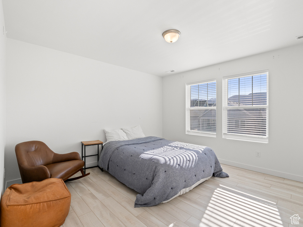 Bedroom with wood finished floors and baseboards