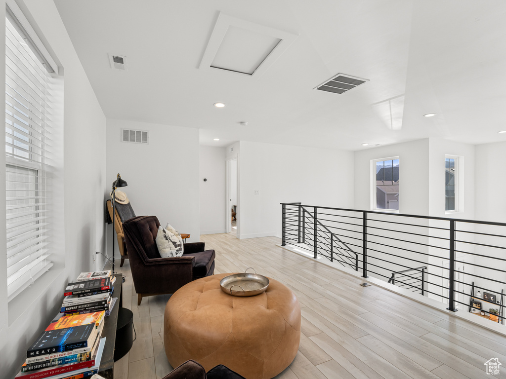 Living area featuring visible vents, an upstairs landing, and wood finished floors
