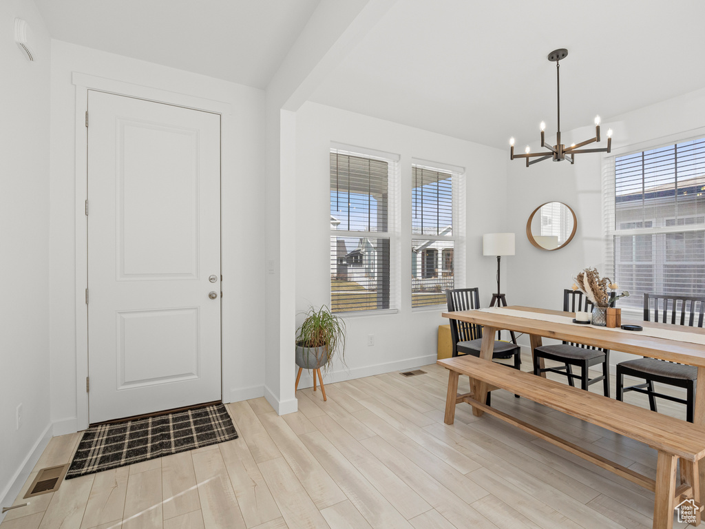 Dining room with a chandelier, light wood-style floors, baseboards, and visible vents