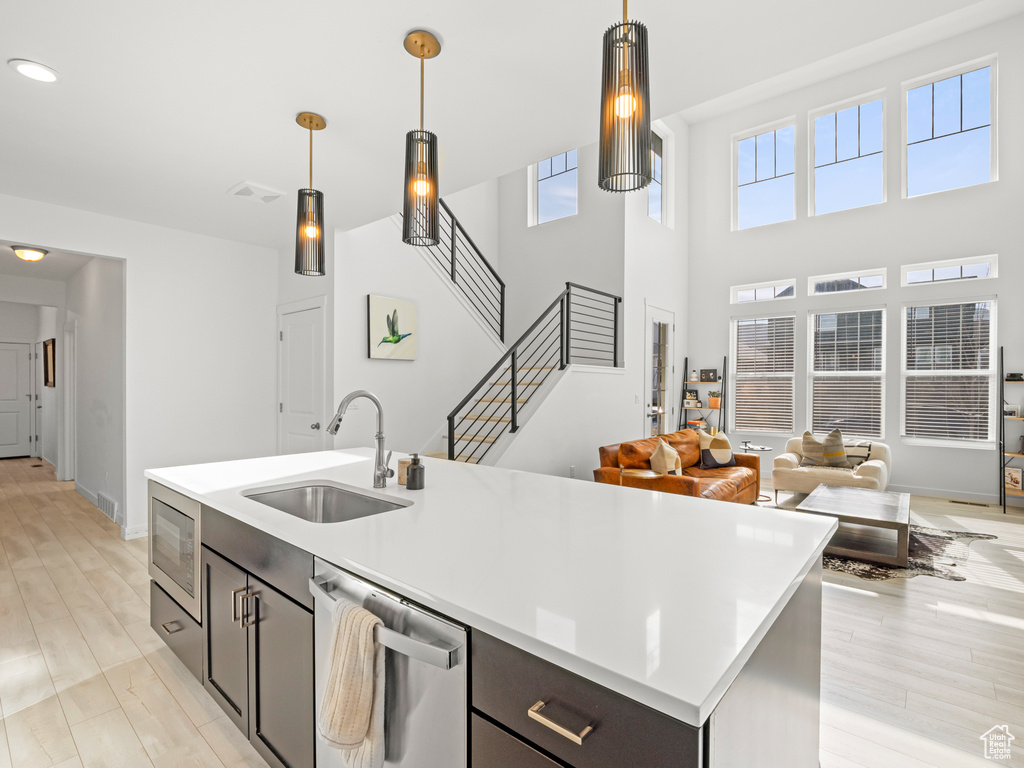 Kitchen featuring visible vents, hanging light fixtures, a sink, light countertops, and appliances with stainless steel finishes